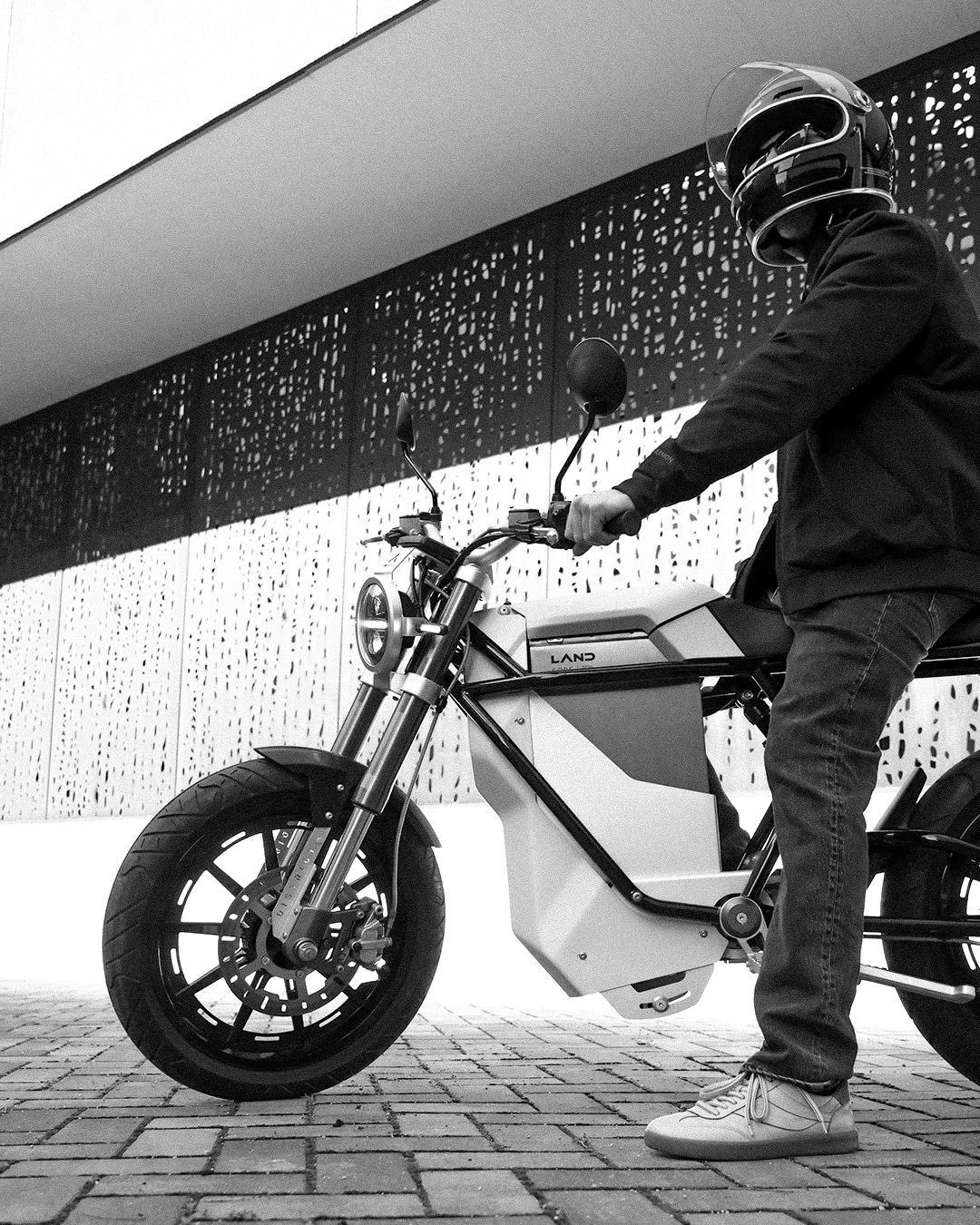 LAND Electric motorcycle at littleBIG House, Cleveland Little Italy — architectural perforated metal façade