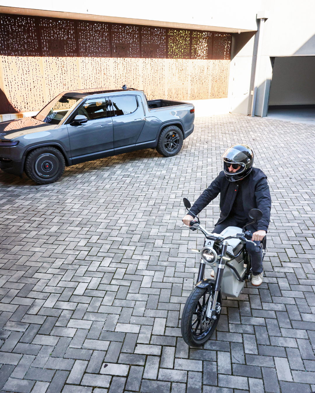 Rivian R1T truck and LAND Electric motorcycle in the forecourt of littleBIG House, Cleveland